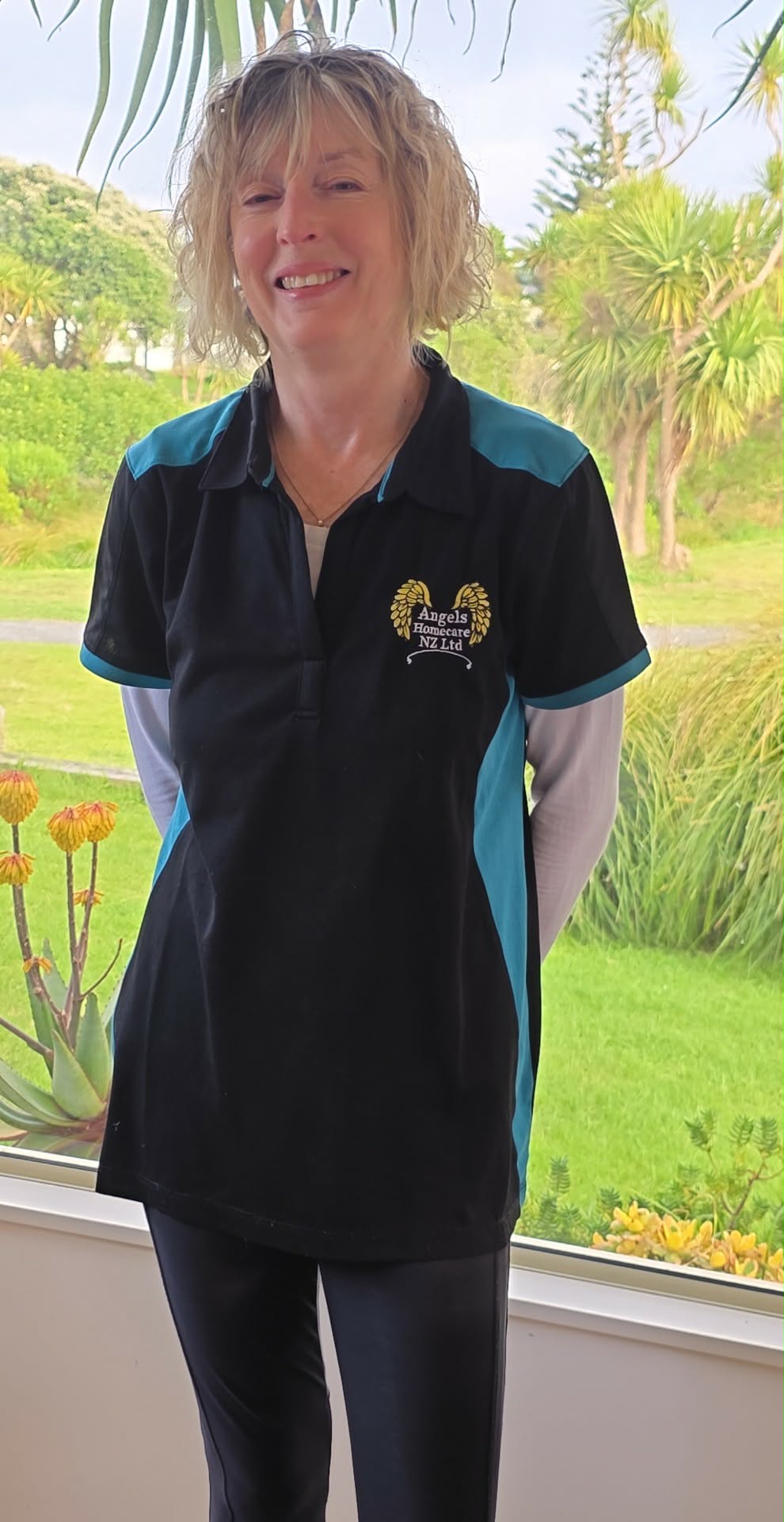 A smiling woman wearing an Angels Homecare uniform